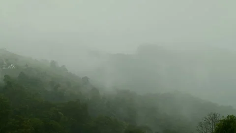 Timelapse of clouds and haze moving above the green hills Stock Footage 261493590