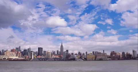 Timelapse of clouds in a blue sky passing over the midtown Manhattan skyline Stock Footage 51306527