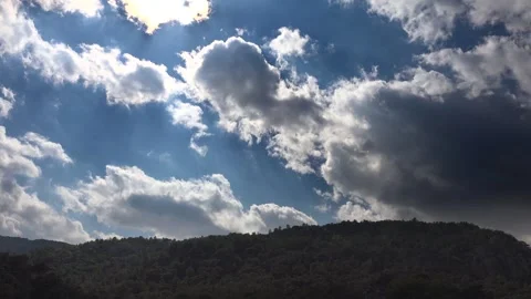 Timelapse clouds drift over forested mountain ridge in humid partly cloudy Stock Footage 339562708