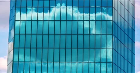 Timelapse  of clouds drifting across the blue glass windows of office skyscraper Stock Footage 332901706