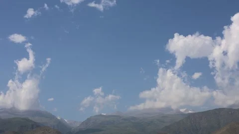 Timelapse of Clouds Drifting Over Mountain Peaks Under Blue Sky Stock Footage 344731492