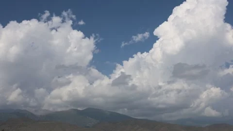 Timelapse of Clouds Drifting Over Mountain Peaks Under Blue Sky Stock Footage 344731793
