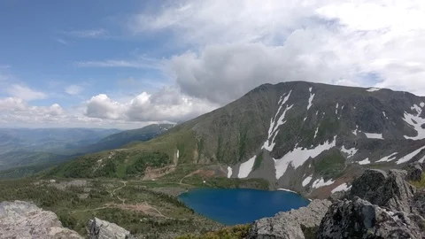 TimeLapse clouds float among big mountains and clear lake 動画素材 119532058