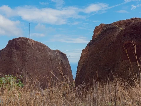 Timelapse clouds float behind a spire rock formation. Ocean background Stock Footage 71776769