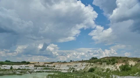 Timelapse clouds float over a sand pit and a lake. Stock Footage 313077599