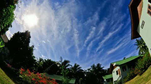 Timelapse of clouds floating above small houses - Fisheye Stock Footage 11275288