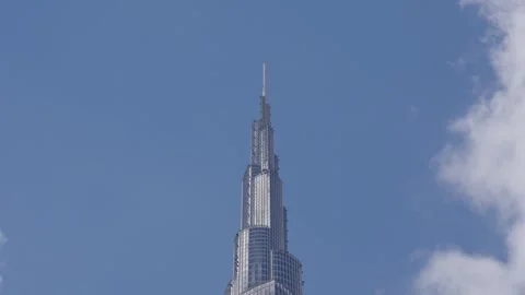 Timelapse of clouds floating across sky and reflections in spire of Burj Khalifa Video stock 331728646