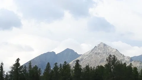 Timelapse of clouds floating in the sky over mountain peaks and forest Stock Footage 160140870