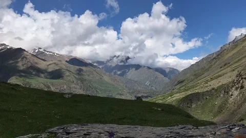 Timelapse of clouds flowing across blue sky over snowy tops of mountains, Georgi Stock Footage 111868017