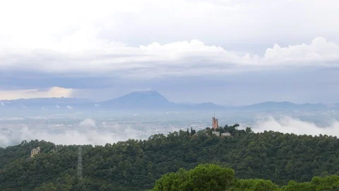 Timelapse clouds fly over Turo del Puig castle and forested mountains Stock Footage 100270853