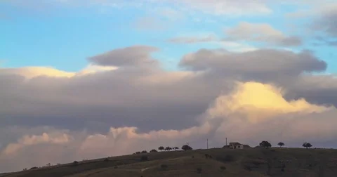 Timelapse of Clouds Forming and Flowing Above a Single House Stock Footage 74080561
