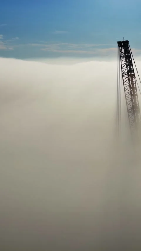 Timelapse clouds forming around a tower crane beneath a dramatic blue sky Stockbeeldmateriaal 336886695