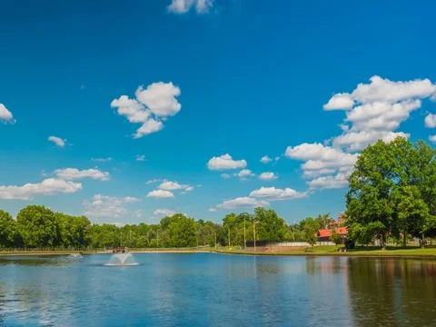 Timelapse of clouds going over a large pond and blue sky reflections Stock Footage 82430536