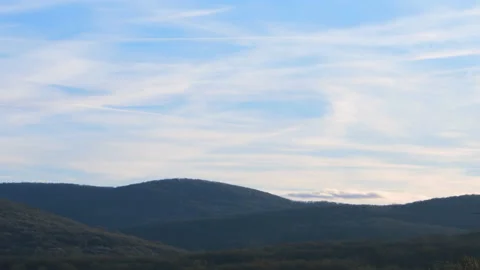 Timelapse. Clouds move over the mountains, planes fly by, leaving an inversion t Stock Footage 229478127