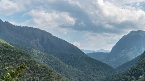 Timelapse of Clouds Moving above Mountain Valley on Sunny Day Stock Footage 99079759
