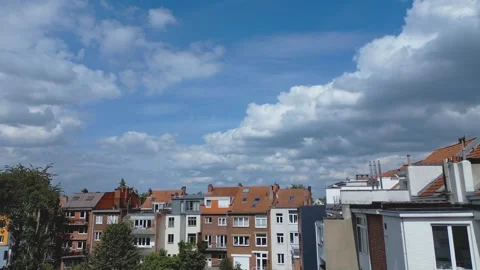 Timelapse of clouds moving across the blue sky over houses in Brussels, Belgium Stock Footage 278938245