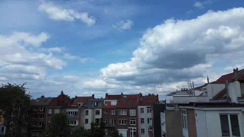 Timelapse of clouds moving across the blue sky over houses in Brussels, Belgium Stock Footage 278938452