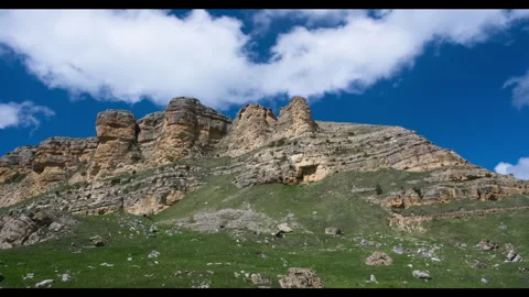 Timelapse: clouds moving across a blue sky over high cliffs. Stock Footage 339575411