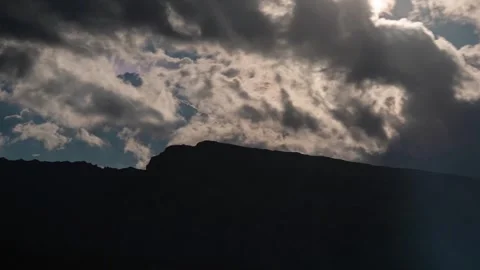 Timelapse of clouds moving and sun rays emerging over Dolomites mountain peak Video stock 247638500