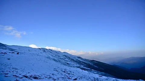 Timelapse of clouds moving behind snow capped hills 스톡 동영상 76996073