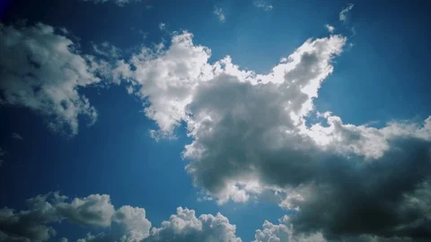 Timelapse: clouds moving in clear blue sky background, sun shines through clouds Stock Footage 120505237