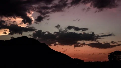 Timelapse of clouds moving in dark sky during sunset Stock Footage 77815343
