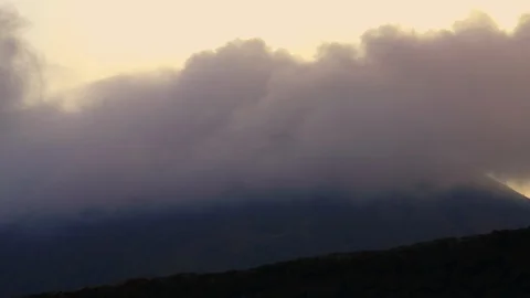 Timelapse of clouds moving fast at dusk over mountains in Bali Stock Footage 124997087