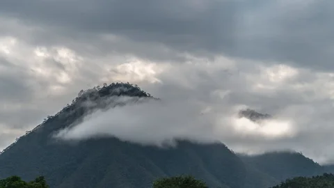Timelapse of Clouds Moving near Mountain Summit Covered with Green Forest on Stock Footage 99079805