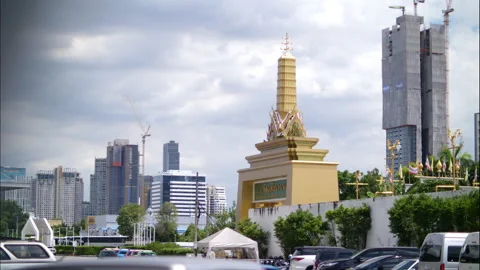 Timelapse of clouds moving over golden Thai temple and modern skyscraper 動画素材 323065586