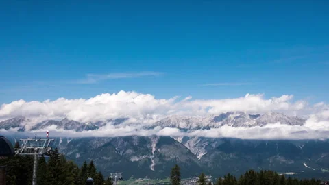 Timelapse of clouds moving over mountains and ski gondola at sun light Stock Footage 249805766