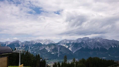 Timelapse of clouds moving over mountains and gondola at sun light in austria Stock Footage 249807701