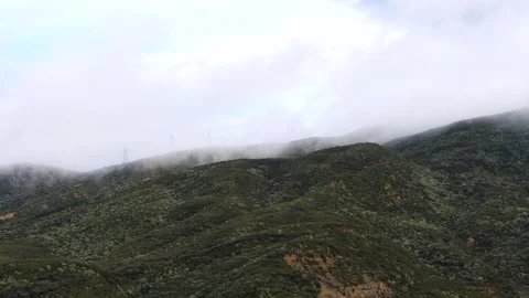 Timelapse clouds moving over mountains, revealing electrical towers Stock Footage 259848516