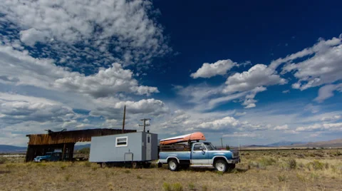 Timelapse of clouds moving over old vehicles in an Idaho field Stock Footage 36320301