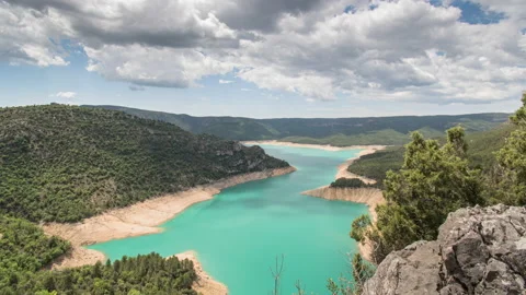 Timelapse of clouds moving over turquoise lake and green mountain valley Stock Footage 221585483