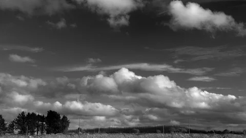 Timelapse of clouds moving from right to left over a countryscape with trees. Stock Footage 86852762