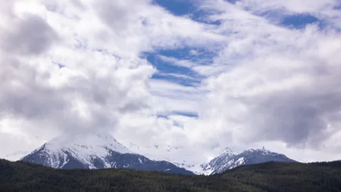 Timelapse clouds over an alpine mountain range, snow capped, terrain, Canada Stock Footage 254512075