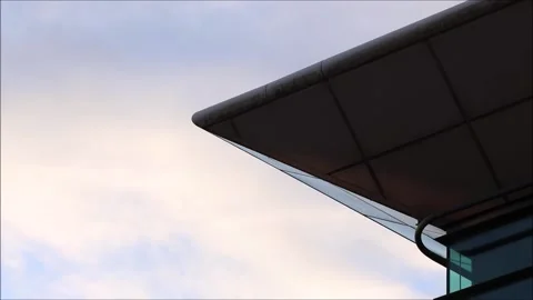 Timelapse clouds over blue sky behind sharp corner of building Stock Footage 132105575