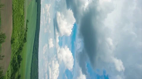 Timelapse of clouds over a field and forest on a summer day, vertical video Video stock 157258586