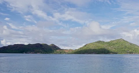 Timelapse: clouds over green hill with body of water in foreground Stock Footage 236542802