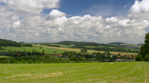 Timelapse clouds over green hills with village. Europe, Germany. Video stock 66530296