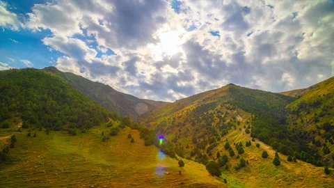 Timelapse of clouds over green mountain valley with rolling hills, Kyrgyzstan Stock Footage 335689074