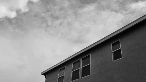Timelapse of clouds over house in black and white Stock Footage 303370007