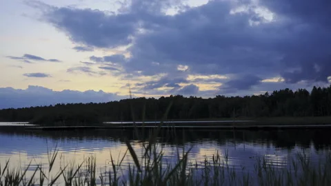 Timelapse of clouds over lake with trees and reflections at blue hour sweden Stock Footage 156130947