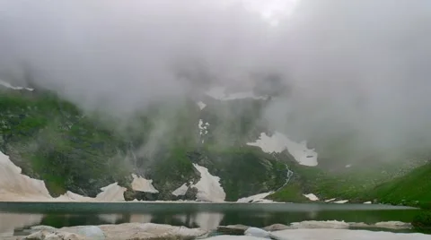 Timelapse of clouds over a mountain lake with ice floes Vídeos de archivo 65764275