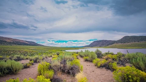 Timelapse - Clouds over the mountain rage by the lake - 4K Stock Footage 80634248