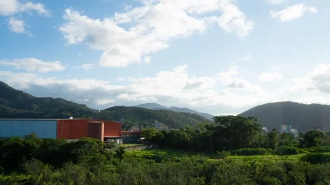 Timelapse of clouds over mountains and industrial buildings in Balneário Stock Footage 329010080