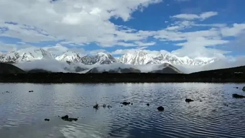 Timelapse of Clouds Over Serene Plateau Lake with Snow-Capped Mountains, Tibet, Vídeo Stock 337802844