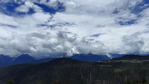 Timelapse of Clouds Over Snow-Capped Mountains and Village, Yunnan, China Stock Footage 338209315
