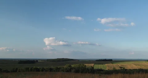 Timelapse of clouds over spreading hills with farm fields Stock Footage 253489730