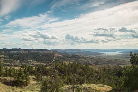 Timelapse clouds over tree covered valley down to lake Stock Footage 62194904